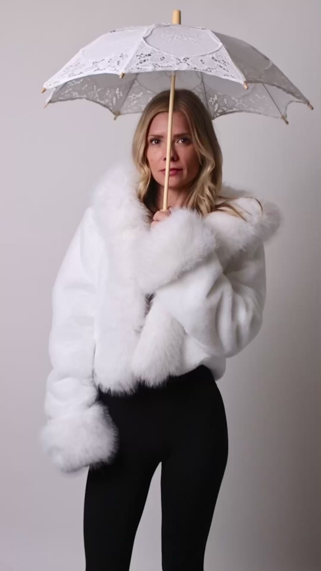 Woman spinning led parasol in studio showing flashing rainbow lights