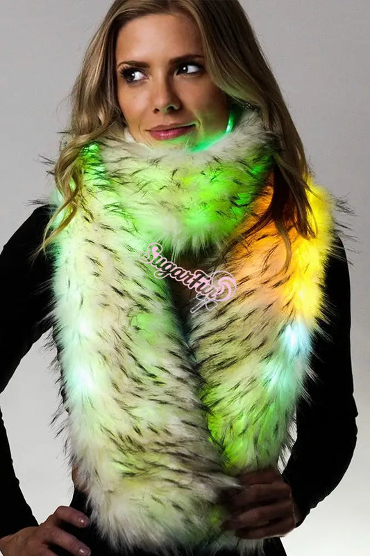 Blonde model wearing plush white fur scarf glowing green and yellow against white background