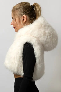 Side view of white faux fur cropped vest showing the armhole fit and silhouette. Aurora Halo festival vest worn over a black long-sleeve top.