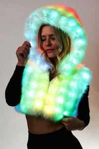 Light-up faux fur festival vest with multi-color LEDs activated. Model wearing the Aurora Halo vest glowing in the dark festival outfit.