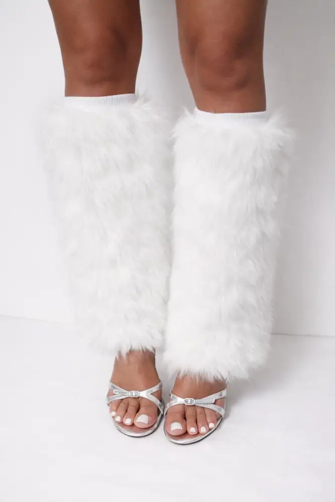 White furry leg warmers worn with silver heels on a white background