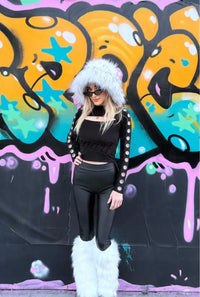women wearing fur hat and leg warmers in front of street art 