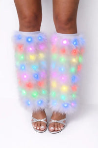 Legs wearing colorful LED leg warmers on a white background