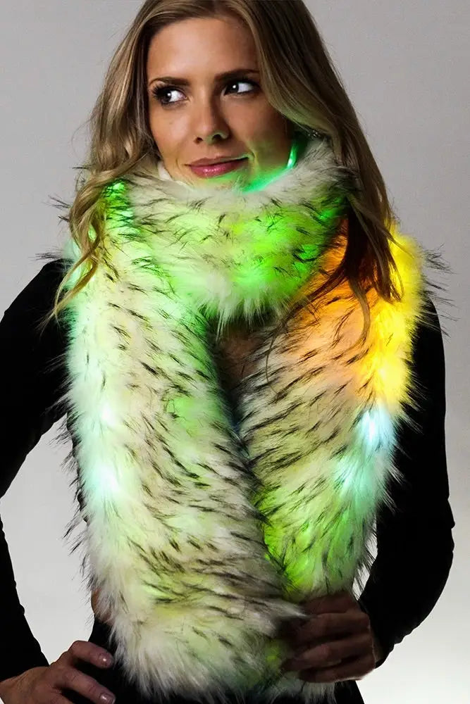 Blonde model wearing plush white fur scarf glowing green and yellow against white background
