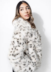 Woman wearing a white fur coat with black spots on a white background
